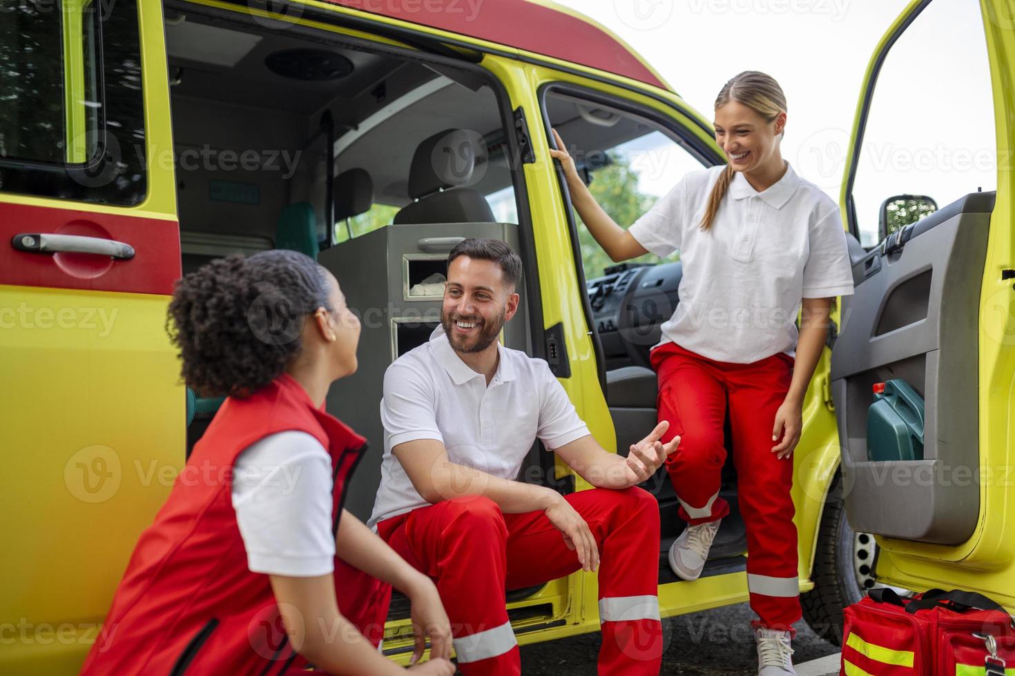 Multi-ethnic paramedics standing at the fromt of an ambulance. Emergency doctor and nurse standing in front of ambulance photo