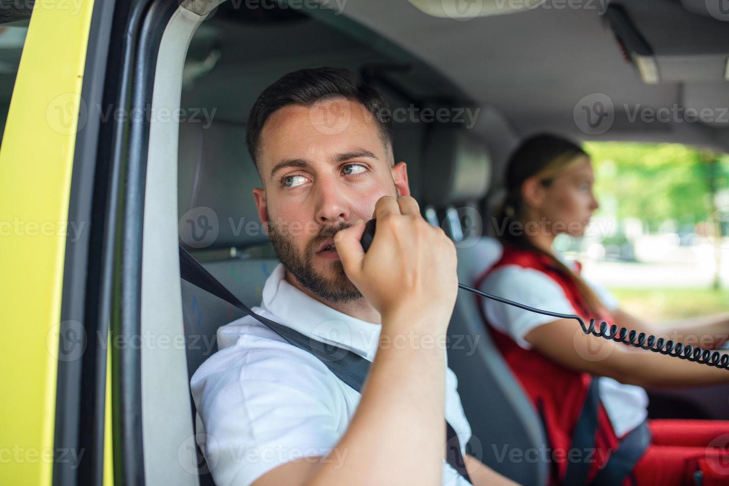 un adulto masculino paramédico es hablando en un radio mientras en ambulancia fuera de un clínica. 21775073 Foto de stock en Vecteezy