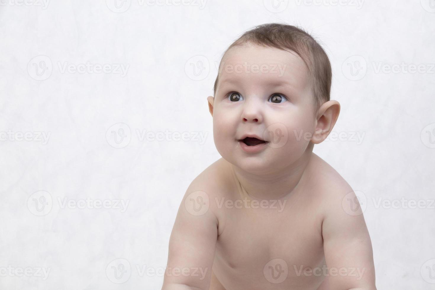 Six month old baby on a white background. Happy boy mid-range. Conceptual photo of fatherhood and motherhood.Alpha generation.