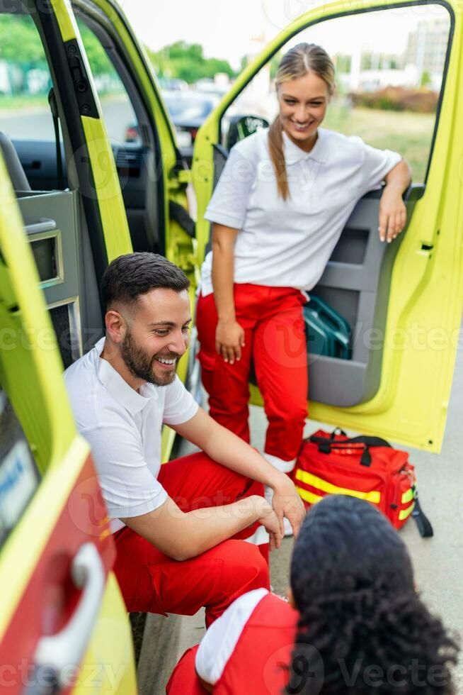 paramédicos a trabajo con un ambulancia. paramédico enfermero y emergencia médico a ambulancia con equipo foto