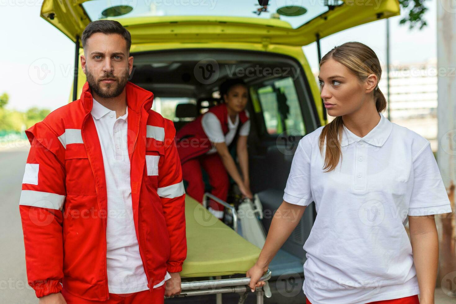 young paramedics moving ambulance stretcher from car. Paramedics in uniform taking stretcher out the ambulance car photo