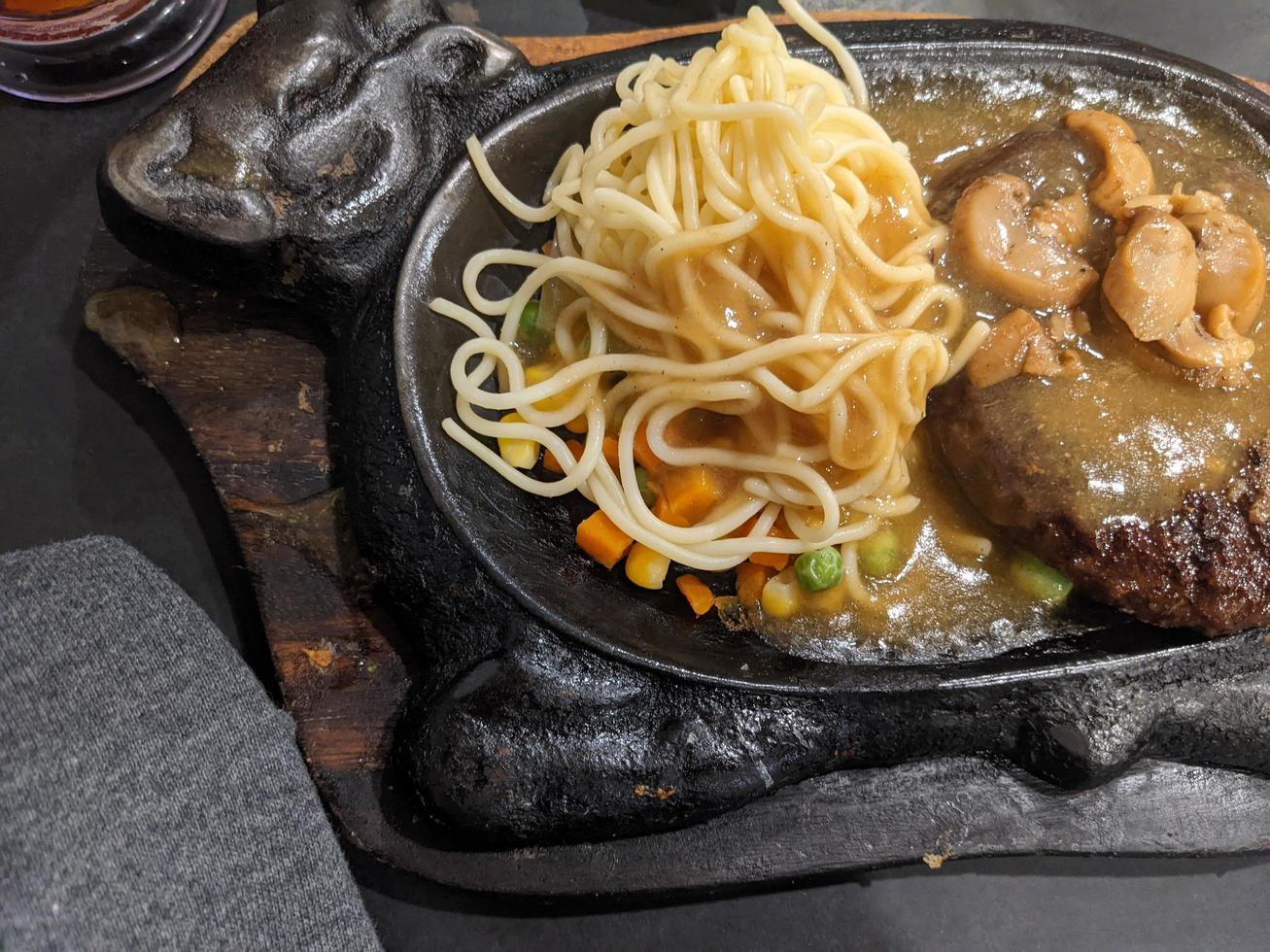 Extra beef steak with noodles and mushroom sauce. The photo is suitable to use for food background, poster and food content media.