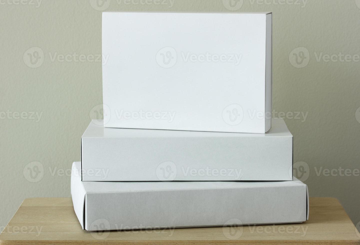 Stack of white cardboard package box mockup on wooden table photo