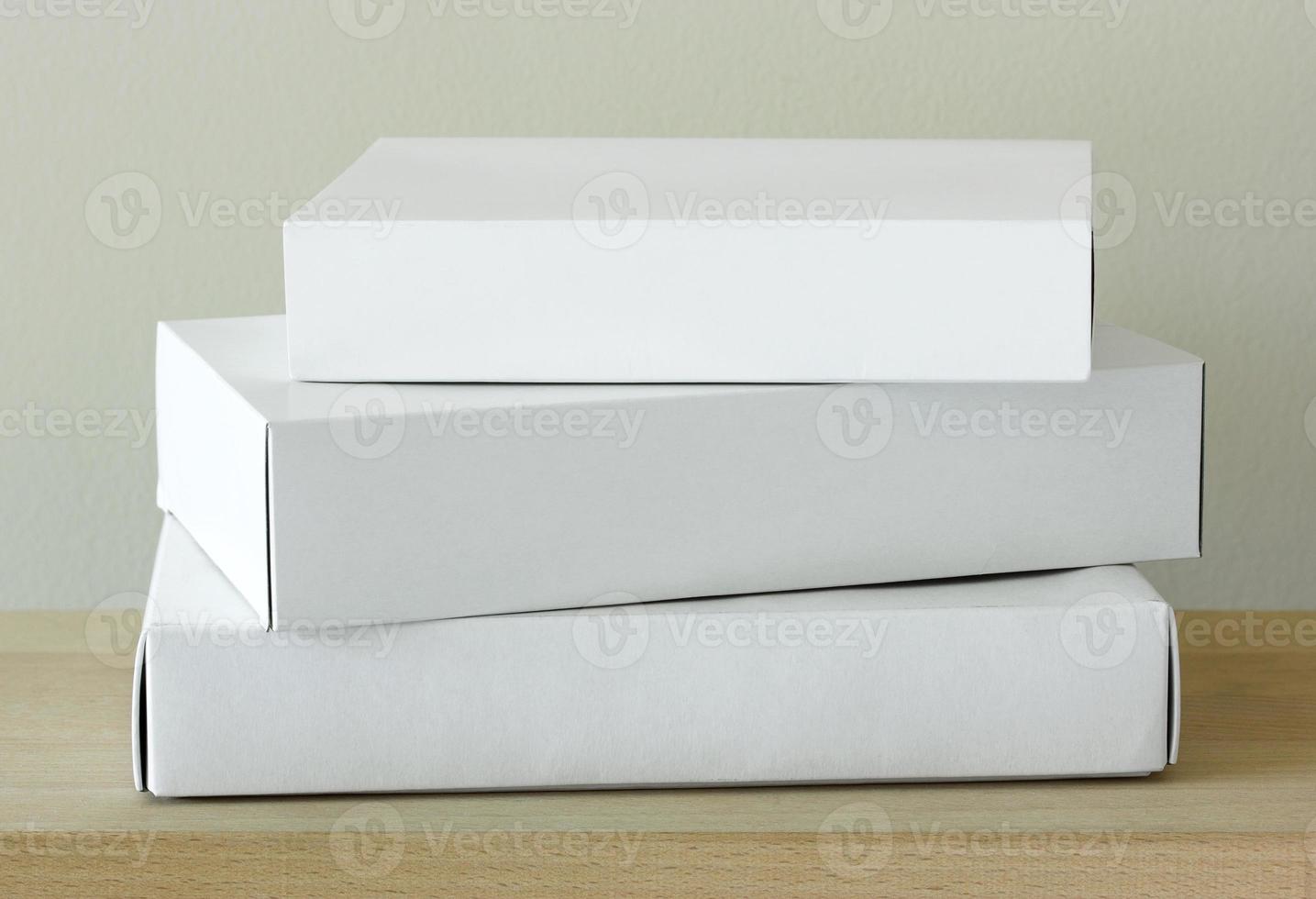 Stack of white cardboard package box mockup on wooden table photo