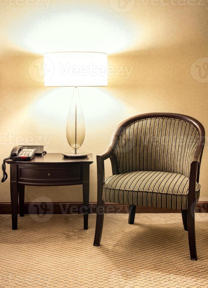 Table lamp with wooden chair in the bedroom at night time photo
