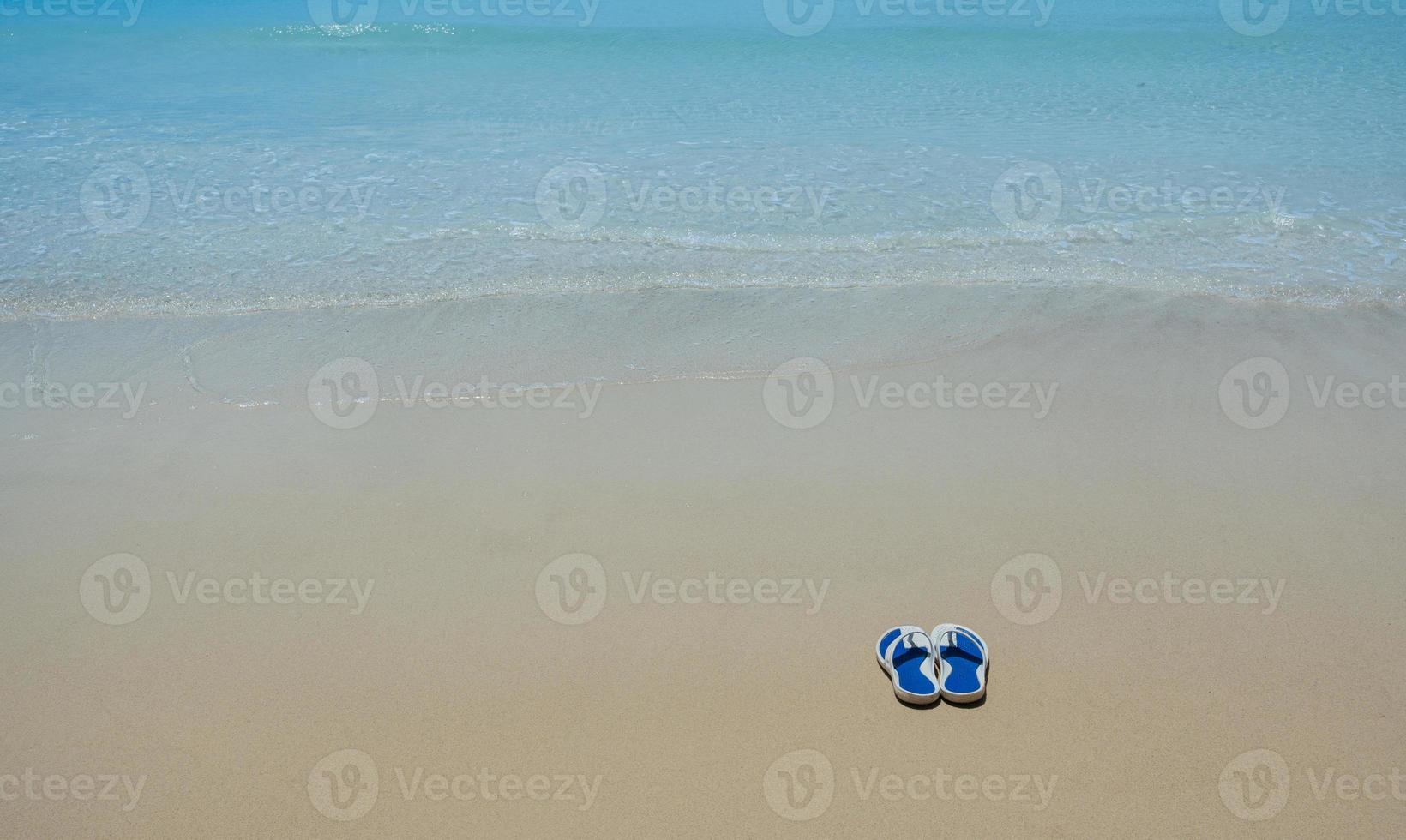 Flip Flops on a sandy ocean beach - Summer vacation concept. photo