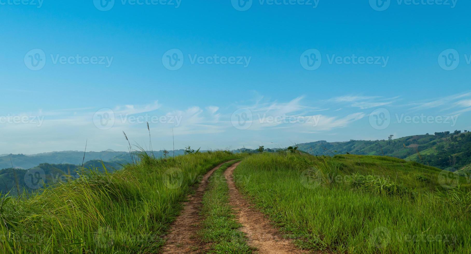 paisaje ver de campo suciedad la carretera camino cruces el colinas con azul cielo antecedentes. foto