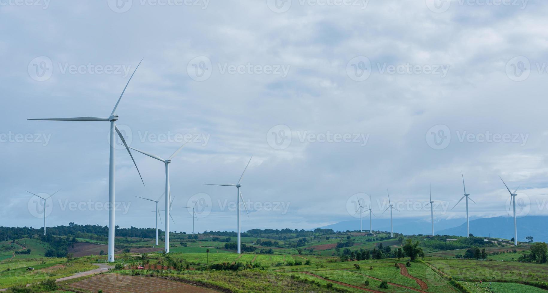 Landscape of panorama wind turbines in agricultural fields with cloudy sky. Renewable friendly energy concept photo