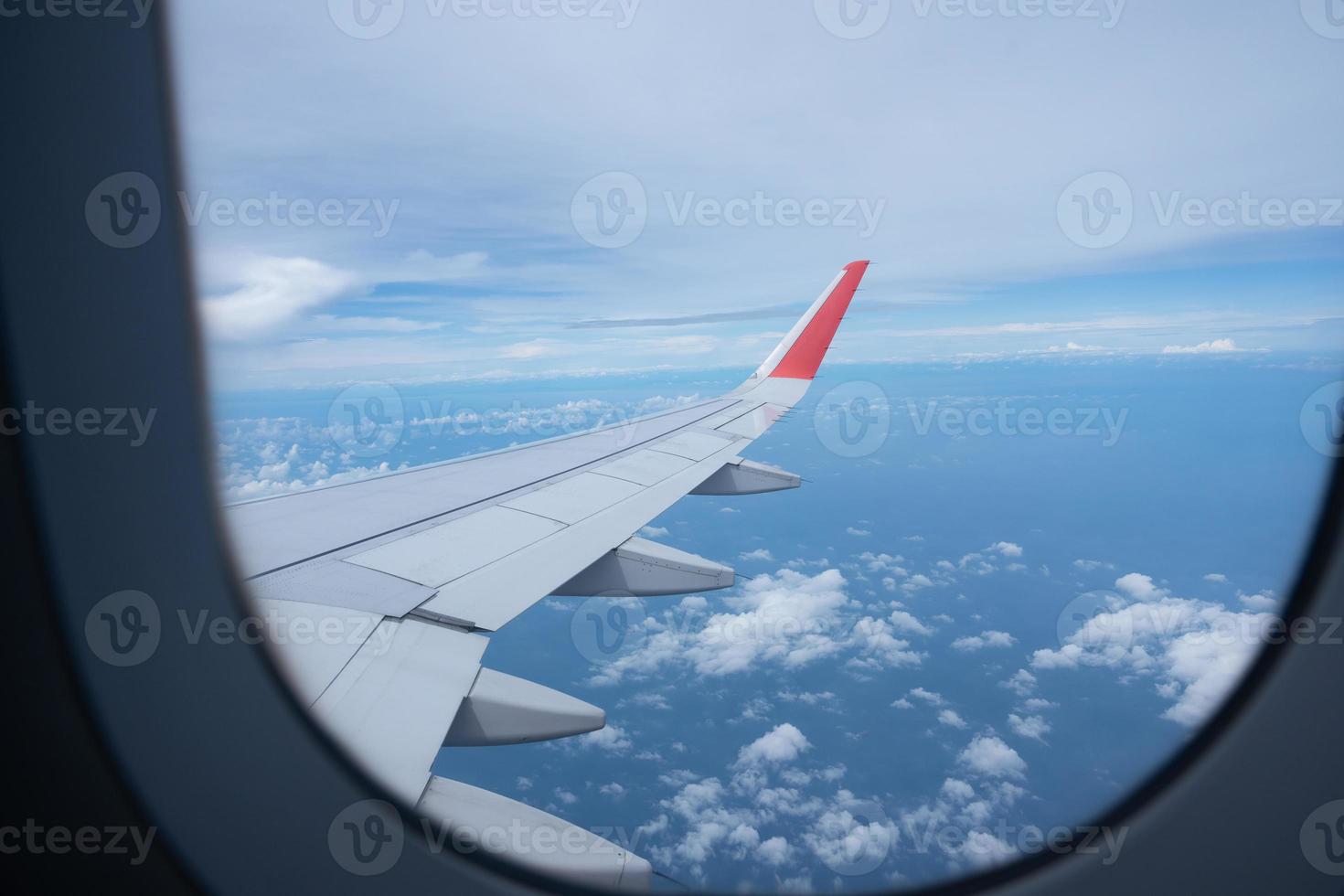 Airplane wing flying above the sky with white clouds. View from aircraft window. flying and traveling concept. photo