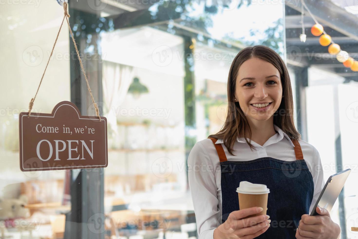 Portrait of a woman, a coffee shop business owner smiling beautifully and opening a coffee shop that is her own business, Small business concept. photo