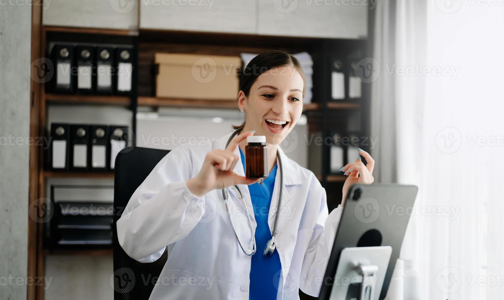 Attractive female doctor talking while explaining medical treatment to patient through a video call with laptop in office photo