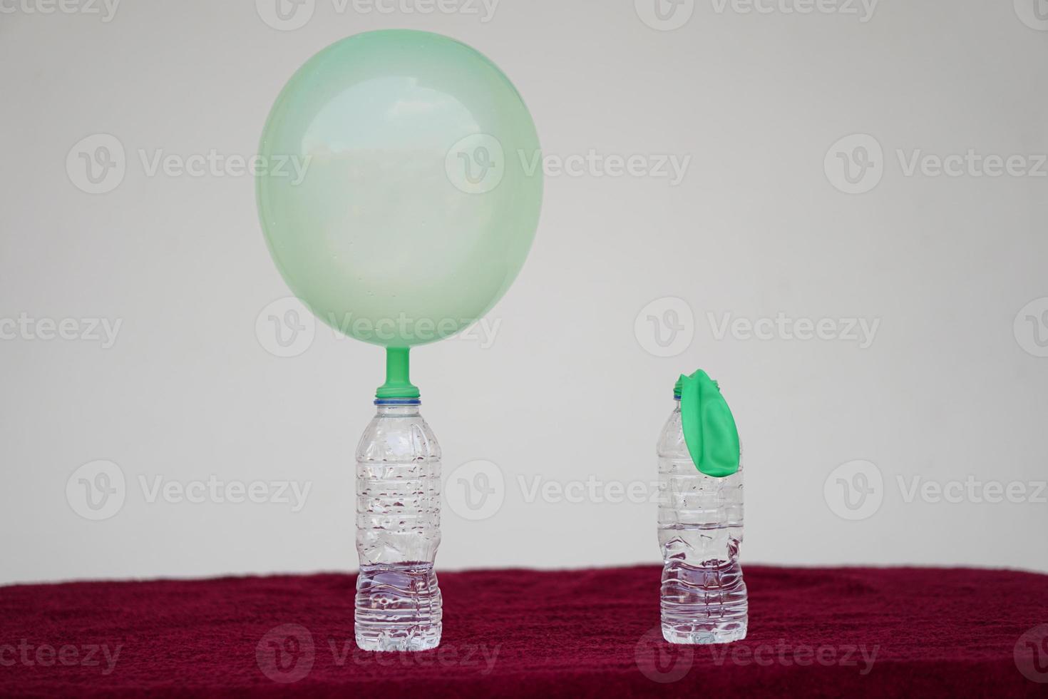 Science experiment , green inflated balloons and flat balloon  on top of transparent test bottles. Concept, science experiment about reaction of chemical substance, vinegar and baking soda. photo