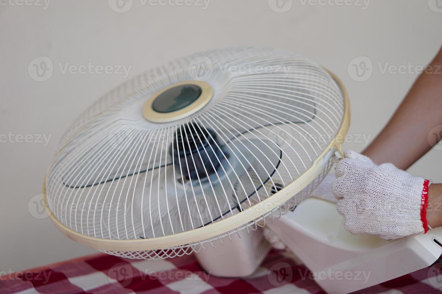 Closeup mechanic hands combine part of electric fan. Concept, maintenace appliance, electric devices in daily life, check ,repair or fix when it has problems for long using. photo