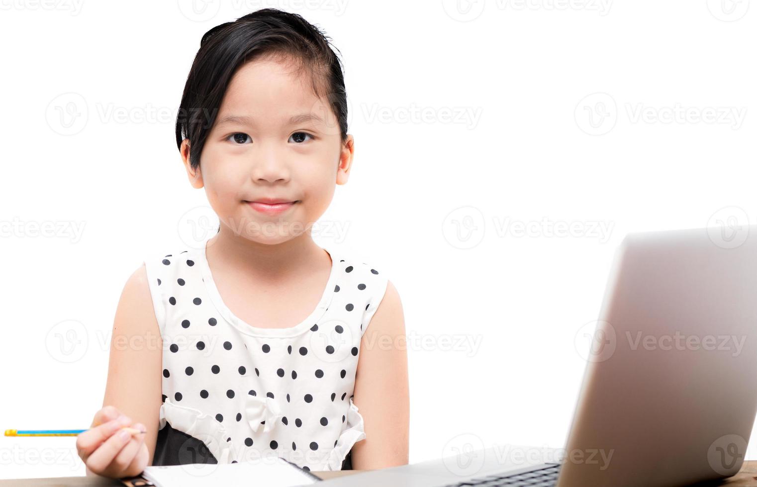 linda estudiante niña escritura deberes con ordenador portátil computadora foto