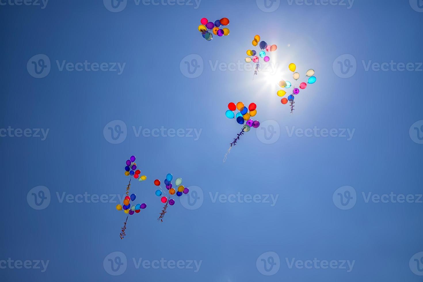 The multi colored helium balloons flying In the blue sky. the concept of a wedding, celebration, anniversary, entertainment photo