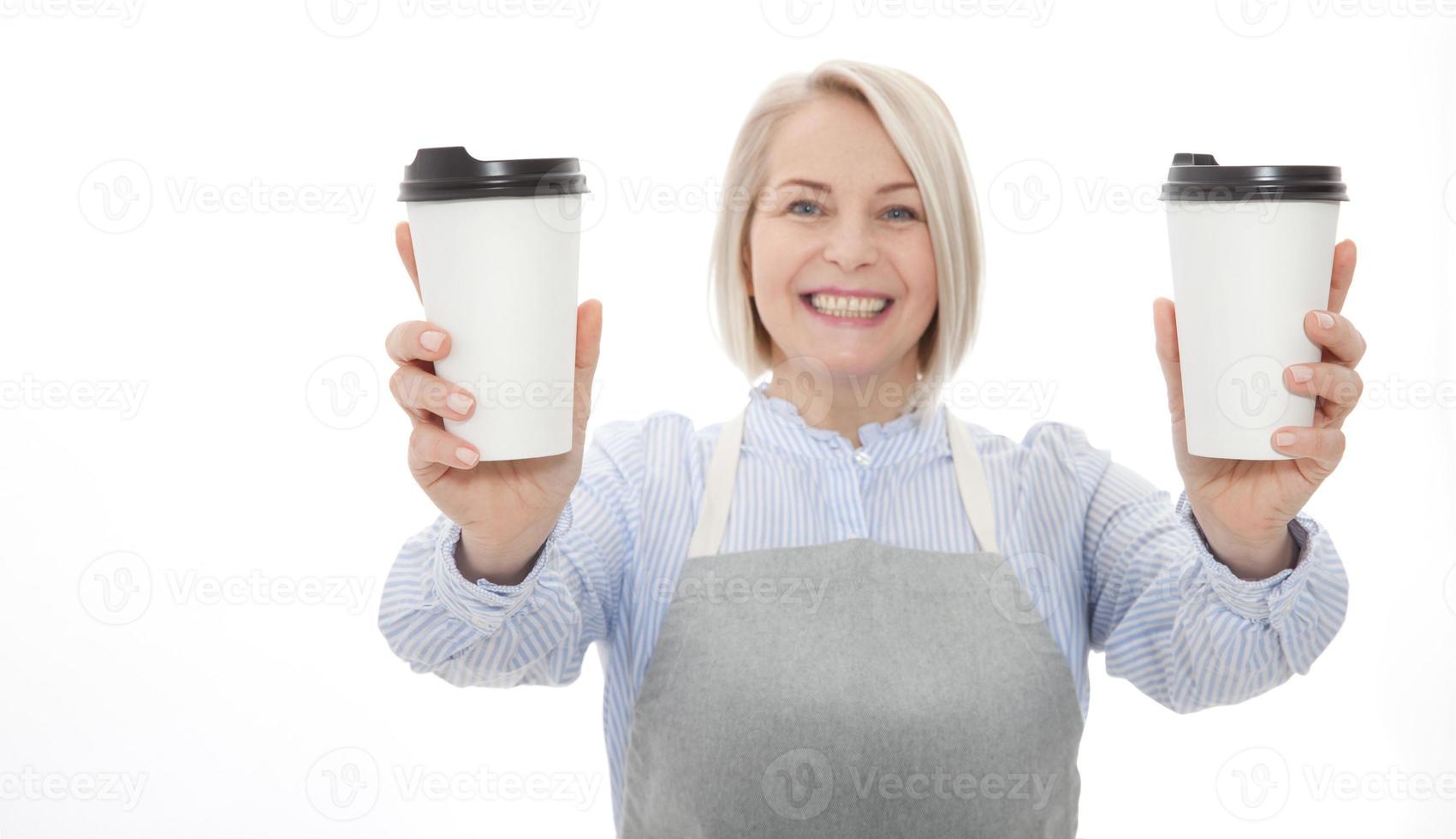 Part-time job coffee break relax leisure pause concept. Friendly pleasant woman barista giving two big latte isolated on gray background copy-space photo