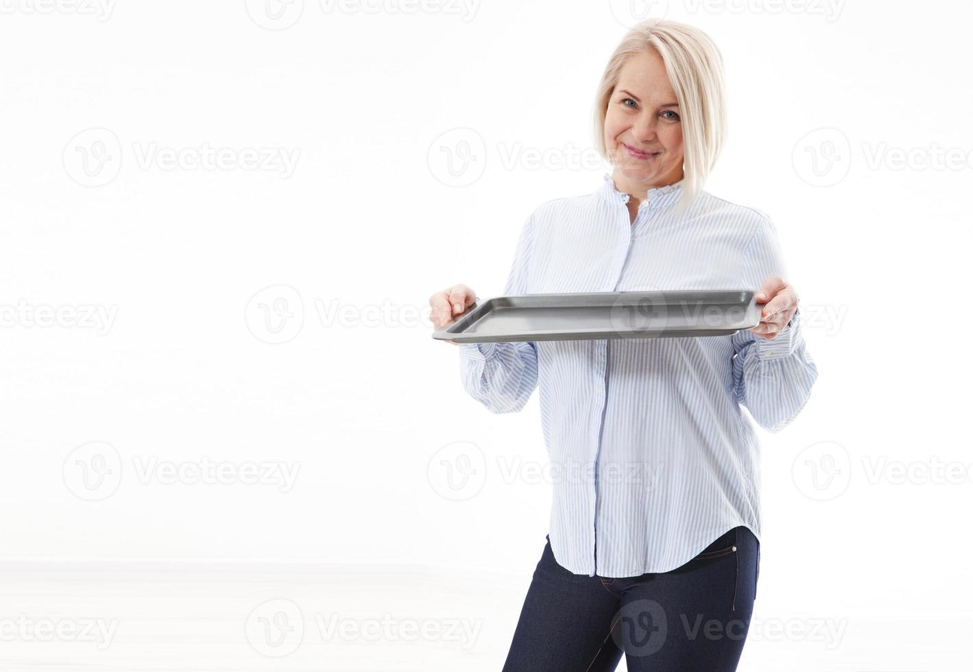 Kitchen woman gives empty tray for your advertising products isolated on white background. Mock up for use photo