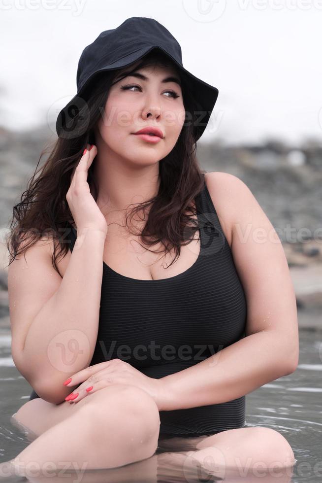 Large size young adult model with big breast in black swimsuit