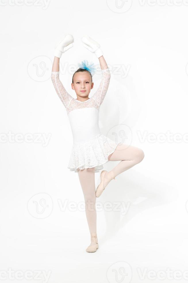 Girl ballet dancer in white ballet tutu skirt dancing on white background with shadow photo