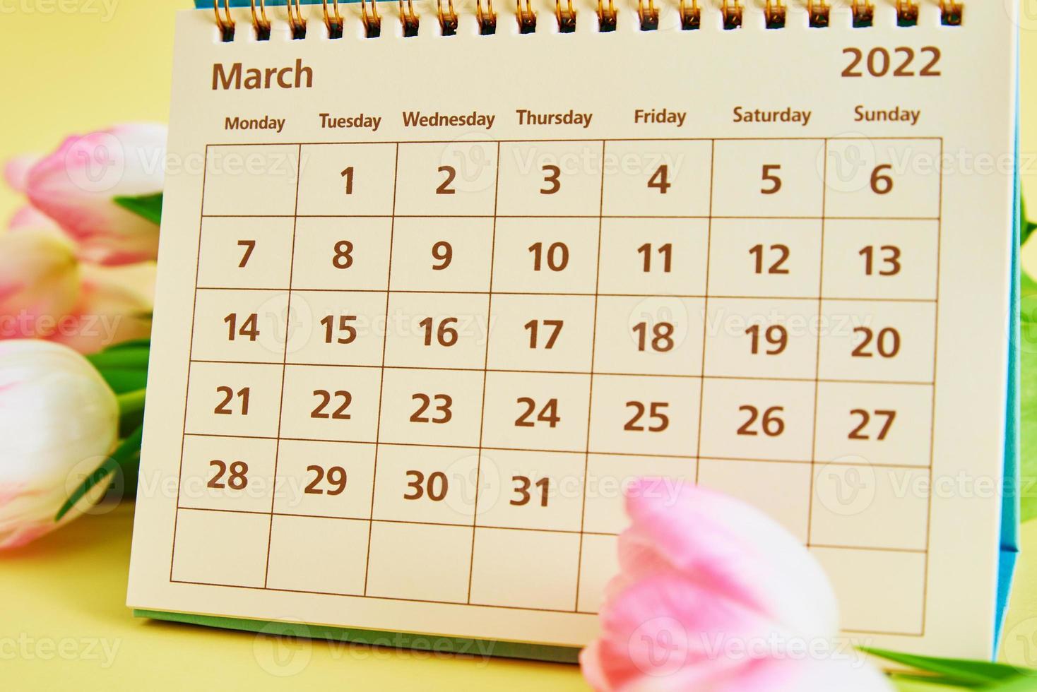 Calendar and flowers on yellow background photo