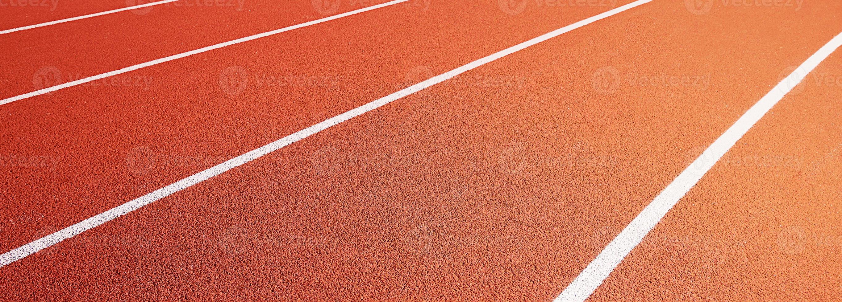 Red running track at stadium with border lanes photo