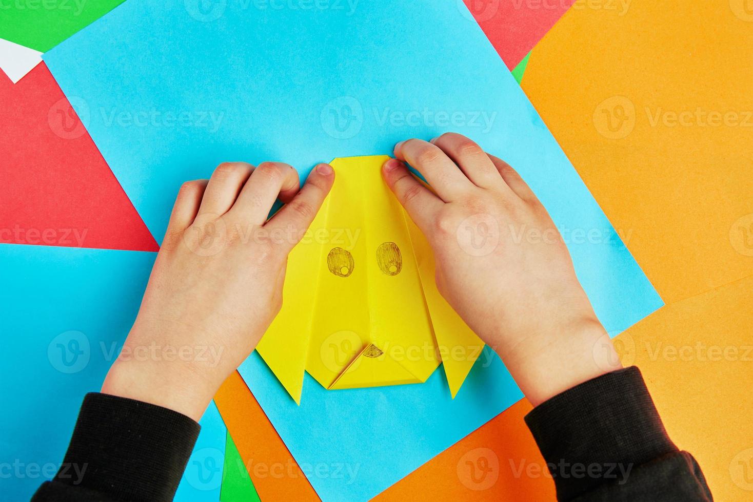 Boy making paper dog origami photo