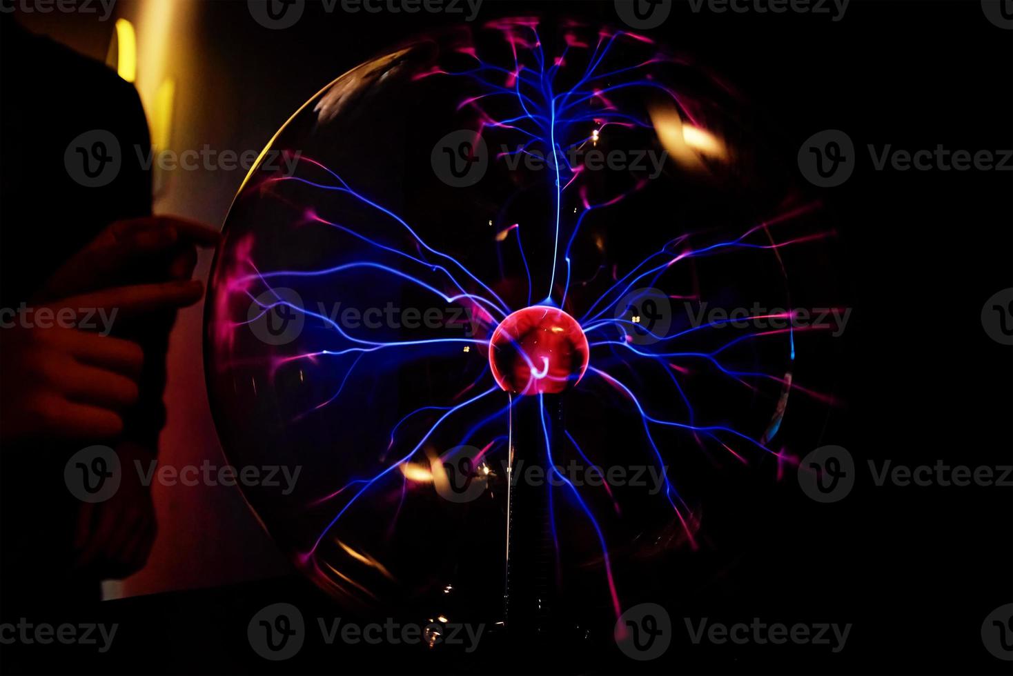 Plasma ball with energy rays on dark background photo