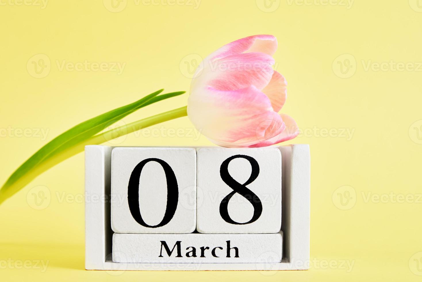 Calendar and flower on yellow background photo