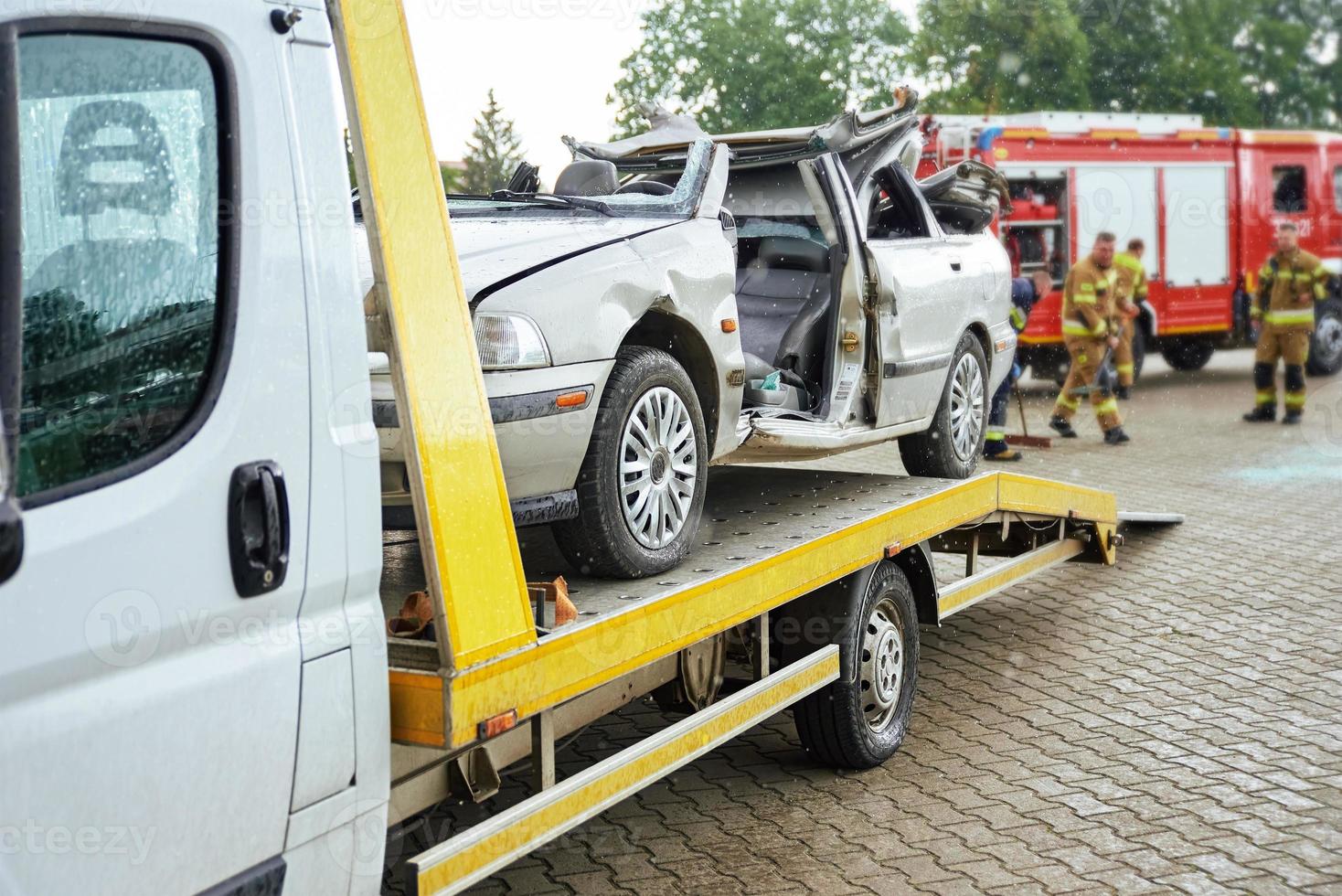 Crashed car loading into tow truck after traffic accident on road photo