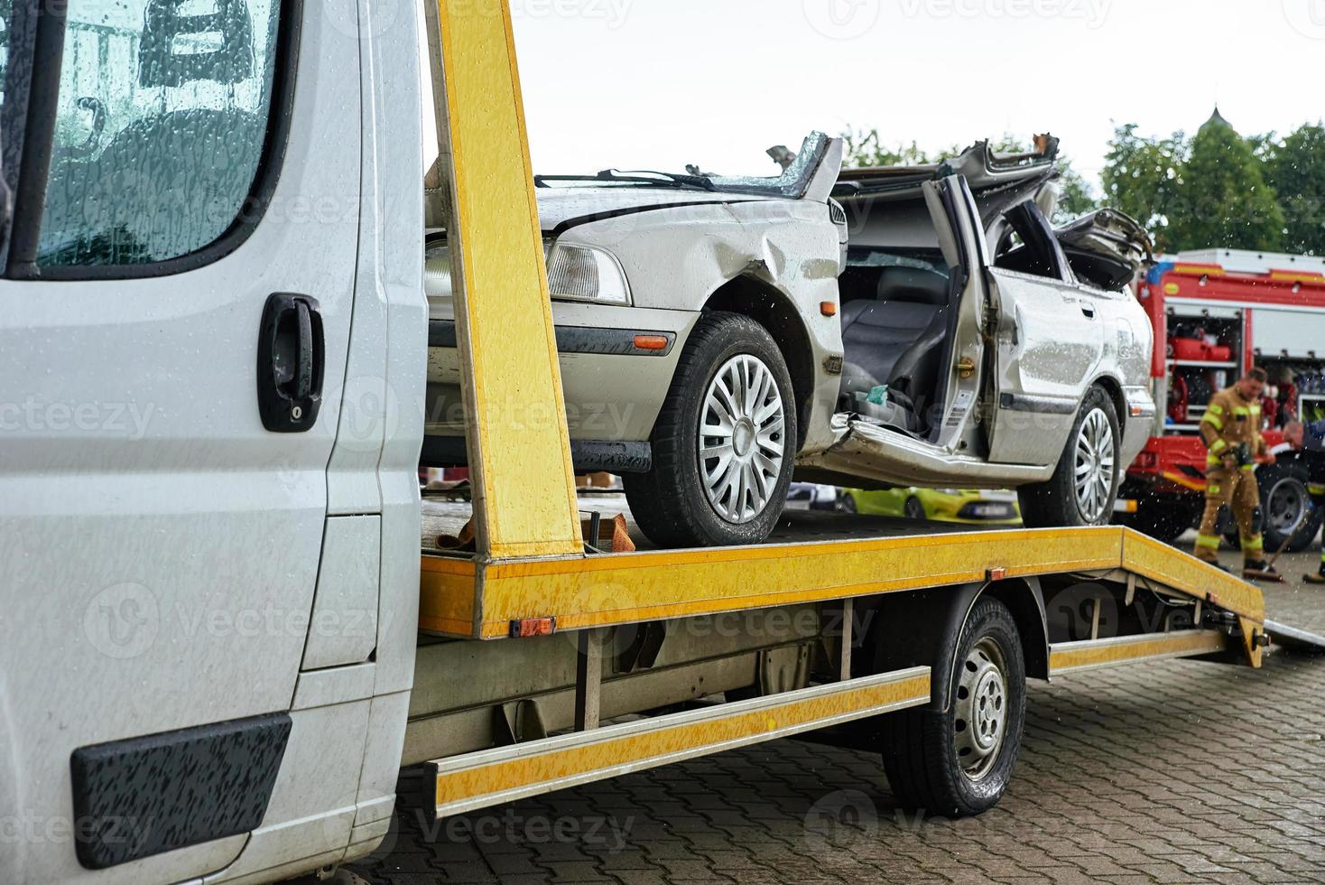 Crashed car loading into tow truck after traffic accident on road photo