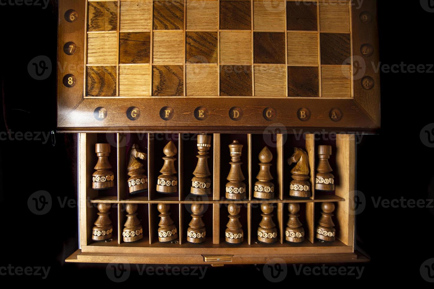 Dark chess pieces lie in a box. A puzzle game with tricky combinations that requires planning and thinking. photo