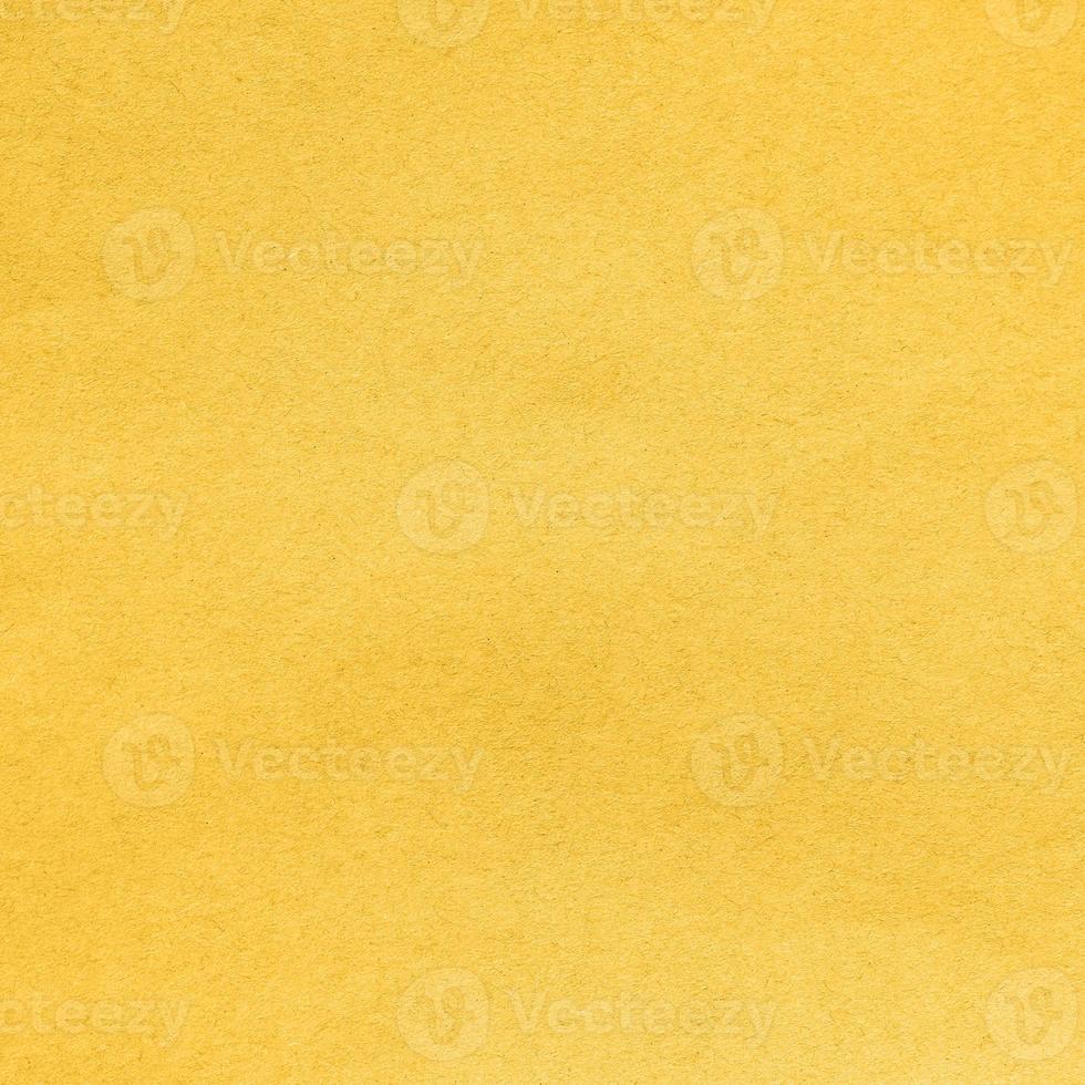 Background from sheet of recycled carton coloring in Fortuna Gold color of year 2021. Cardboard material pattern, backdrop for design photo