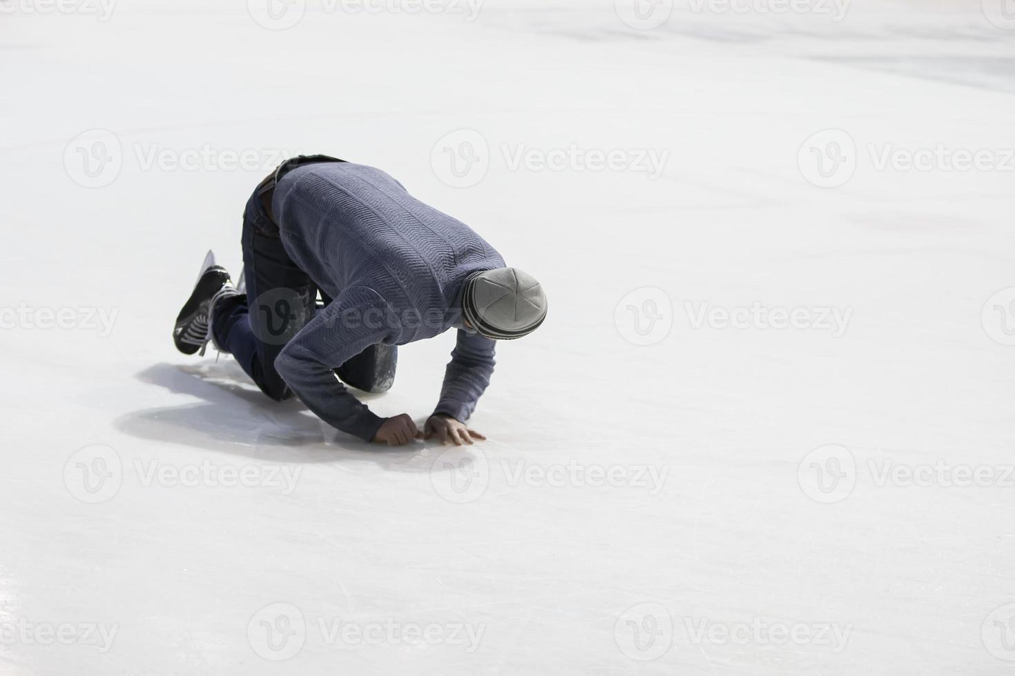 The man fell while skating on the ice. photo