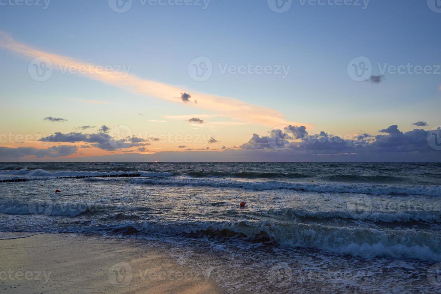 Baltic sea beach with waves at sunset photo