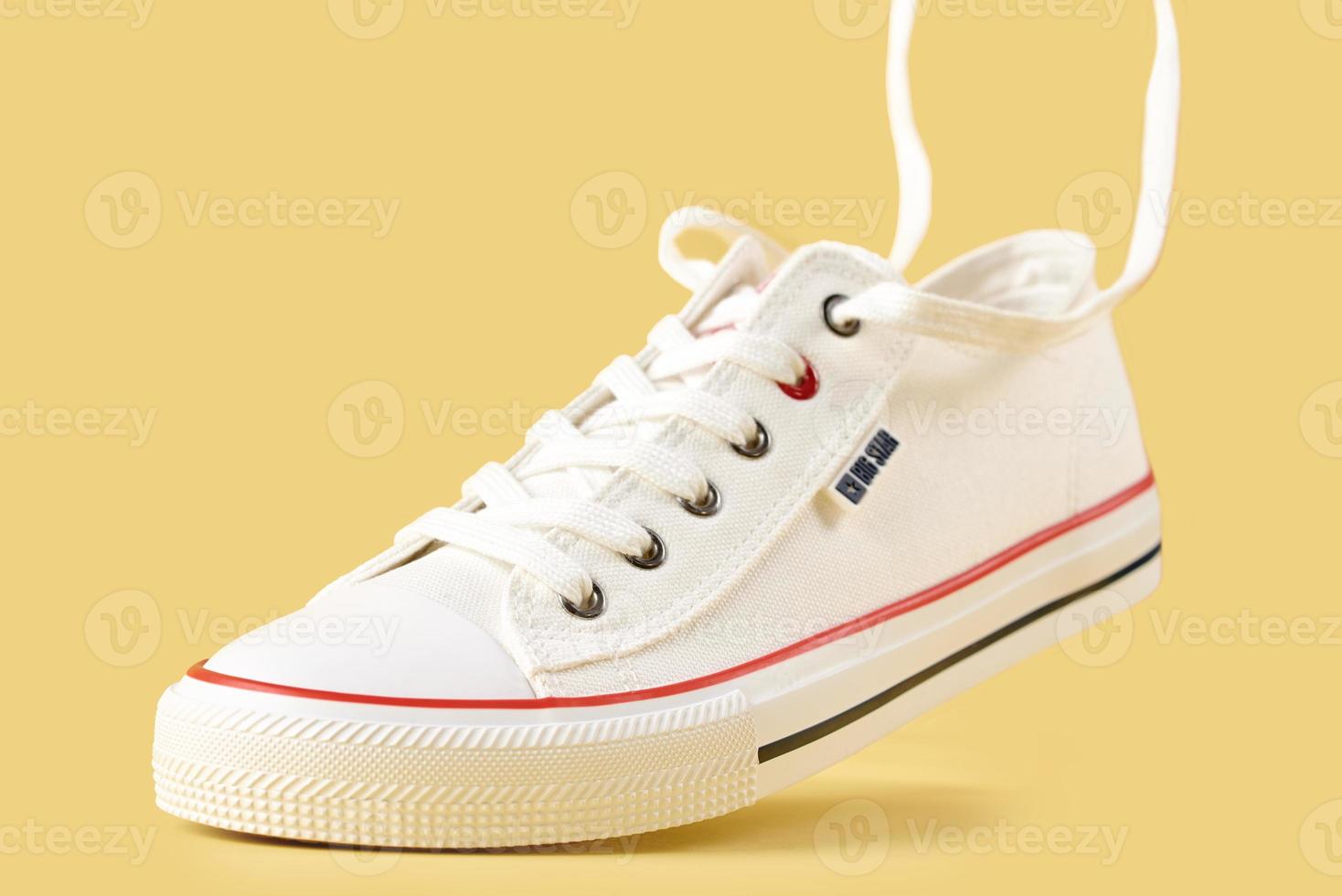 White Big starl sneakers on yellow background, creative minimalism photo