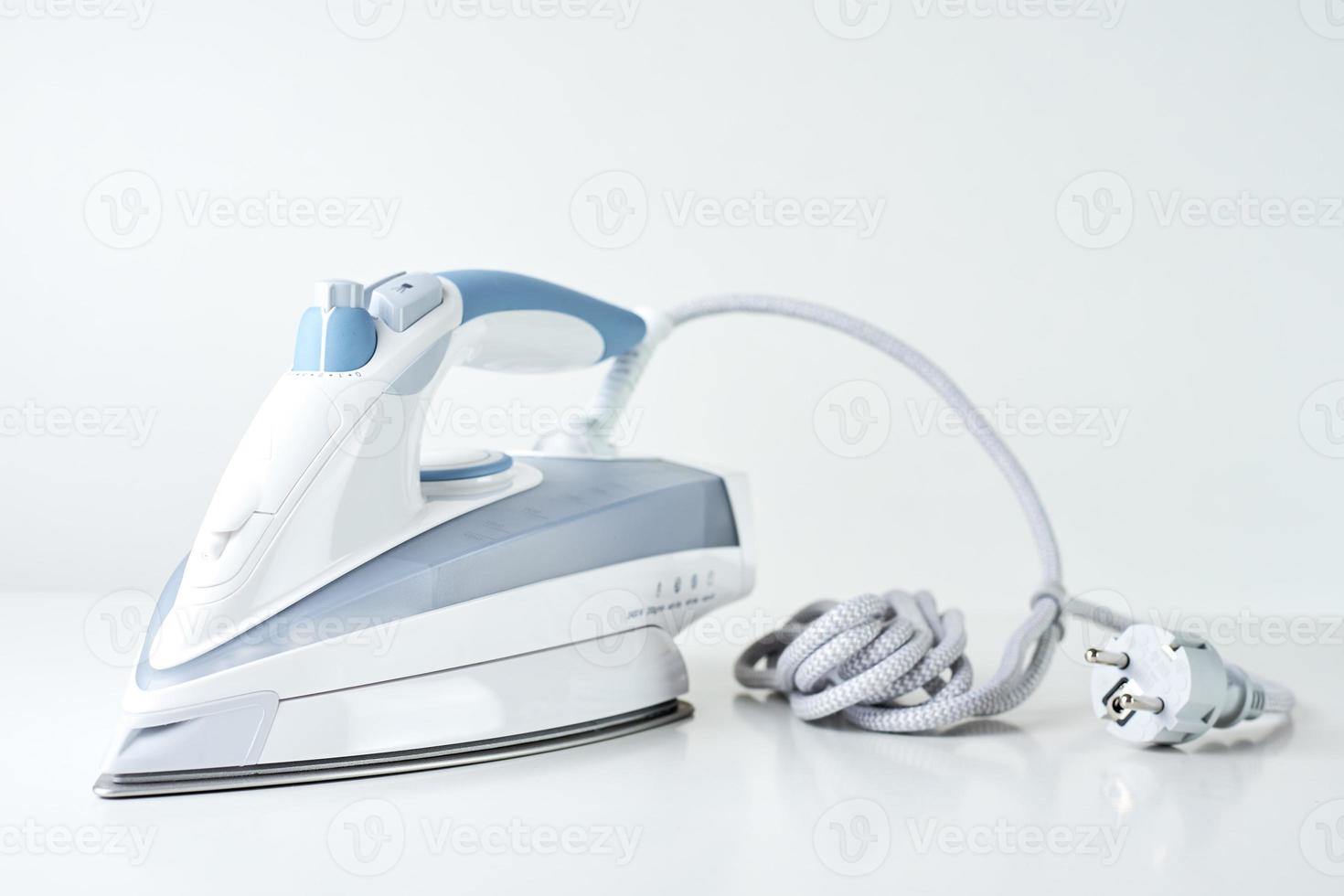 Modern iron with cable on white background photo