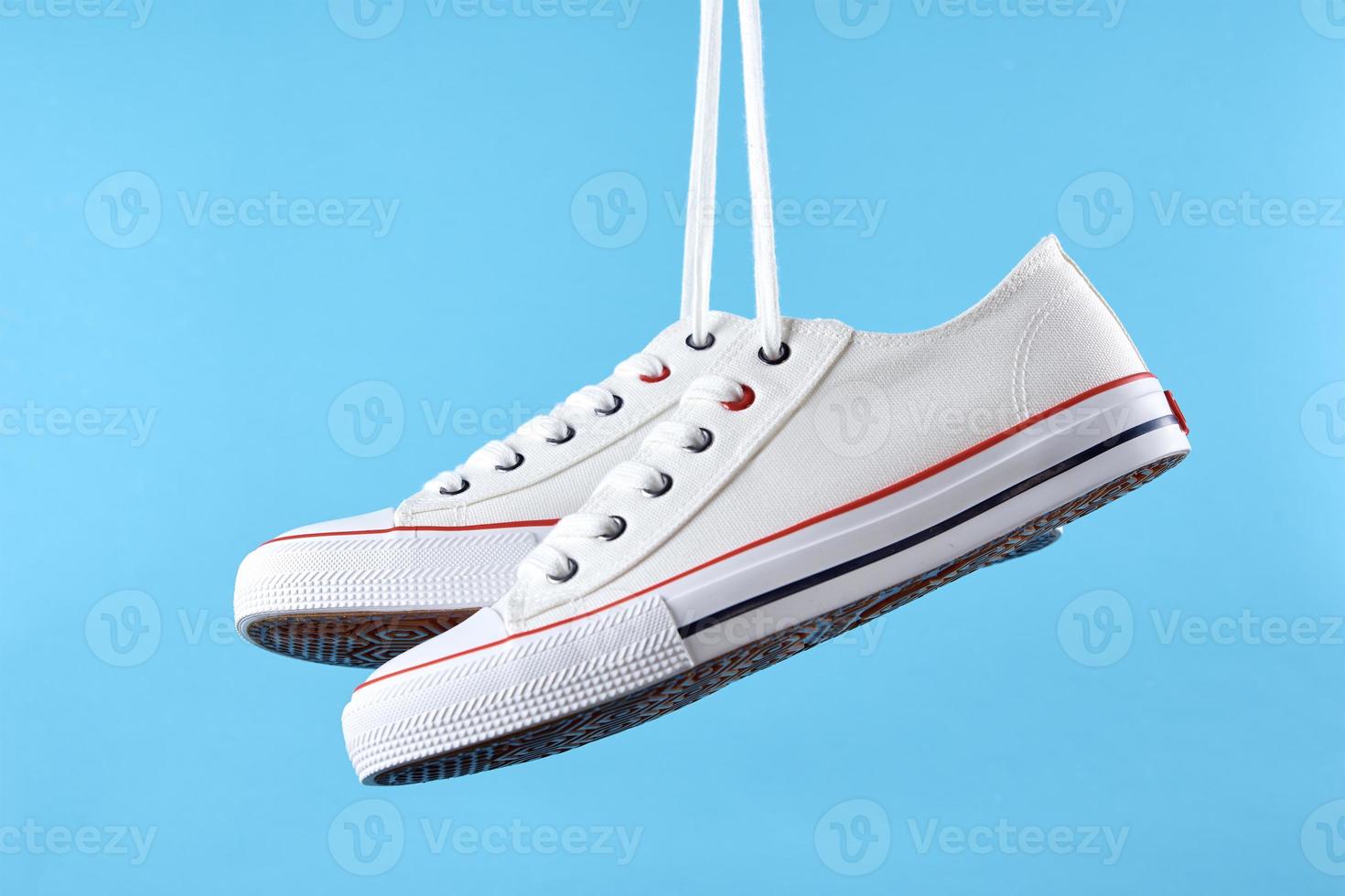 White casual sneakers on blue background, creative minimalism photo