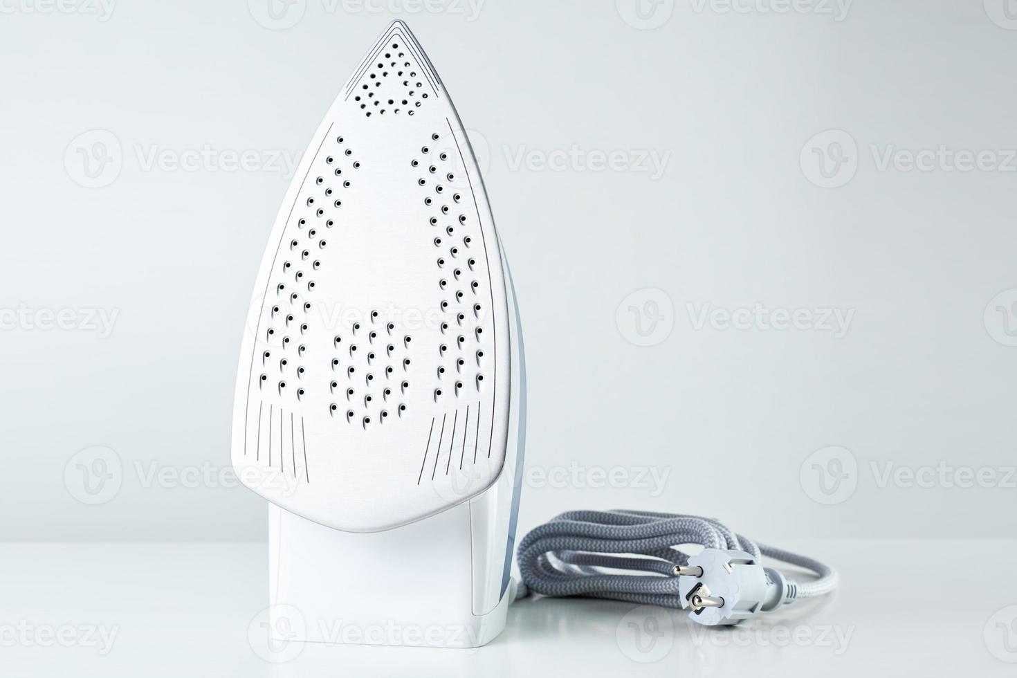 Modern iron with cable on white background photo