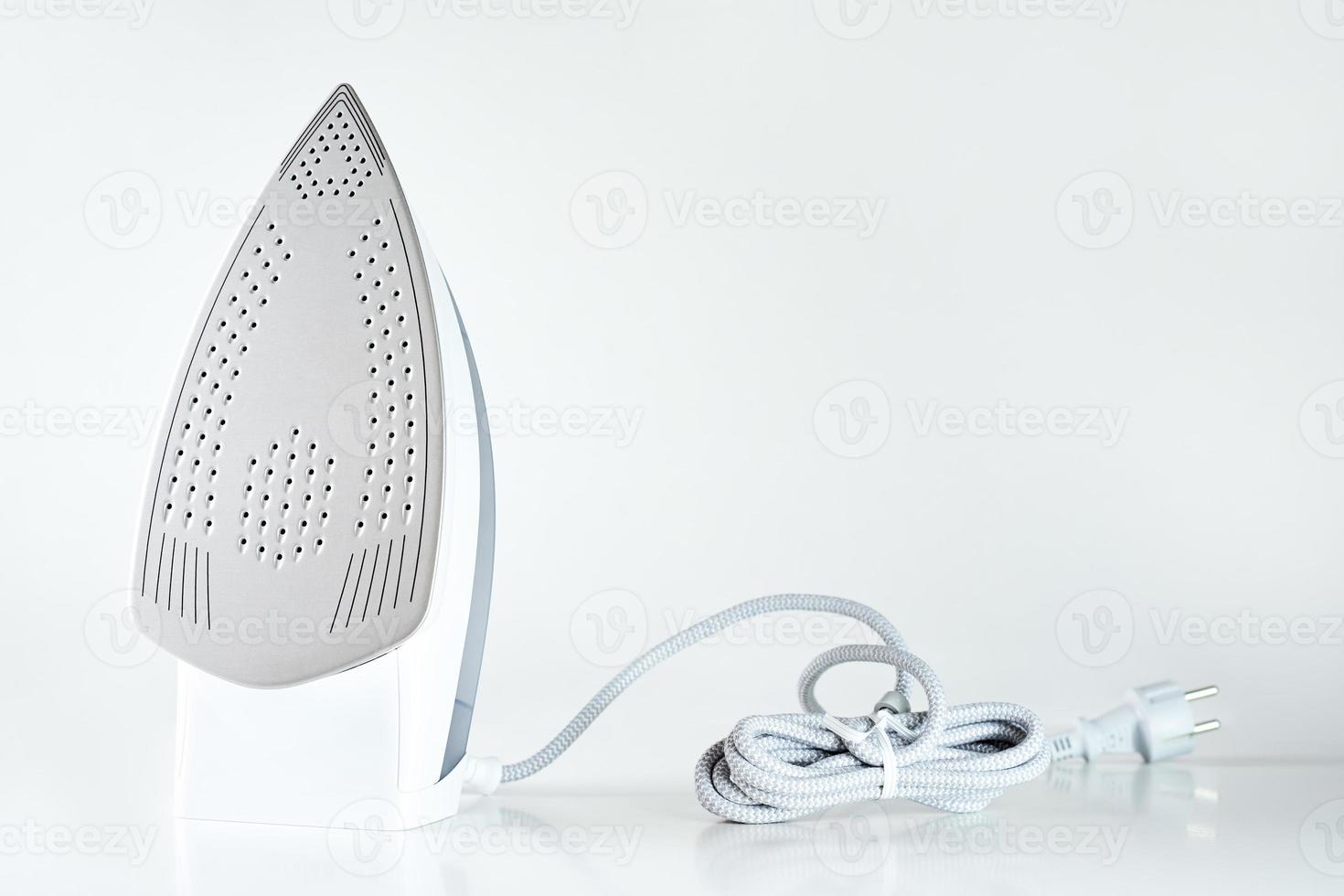 Modern iron with cable on white background photo