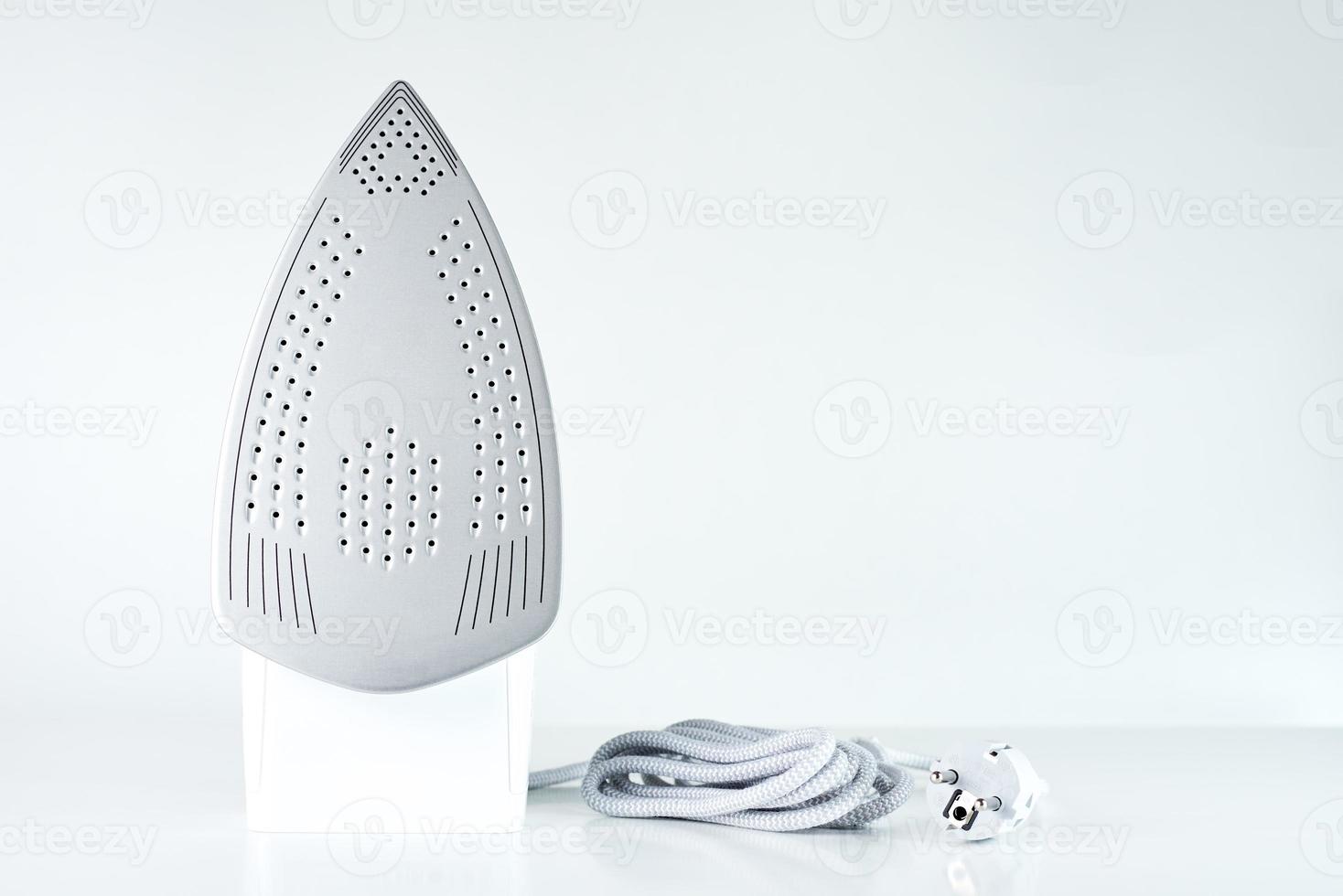 Modern iron with cable on white background photo