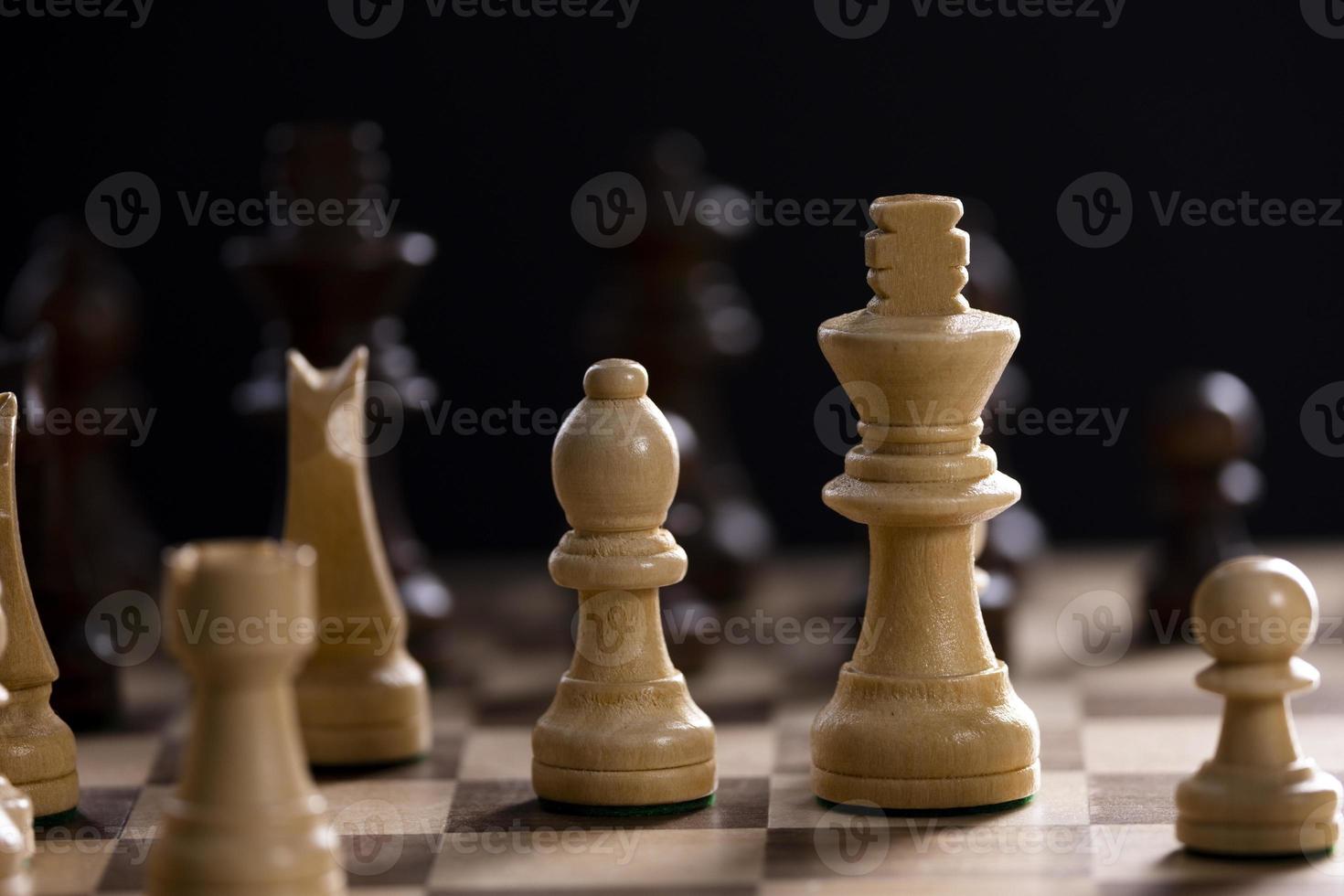 A chess board asnd pieces against black background photo