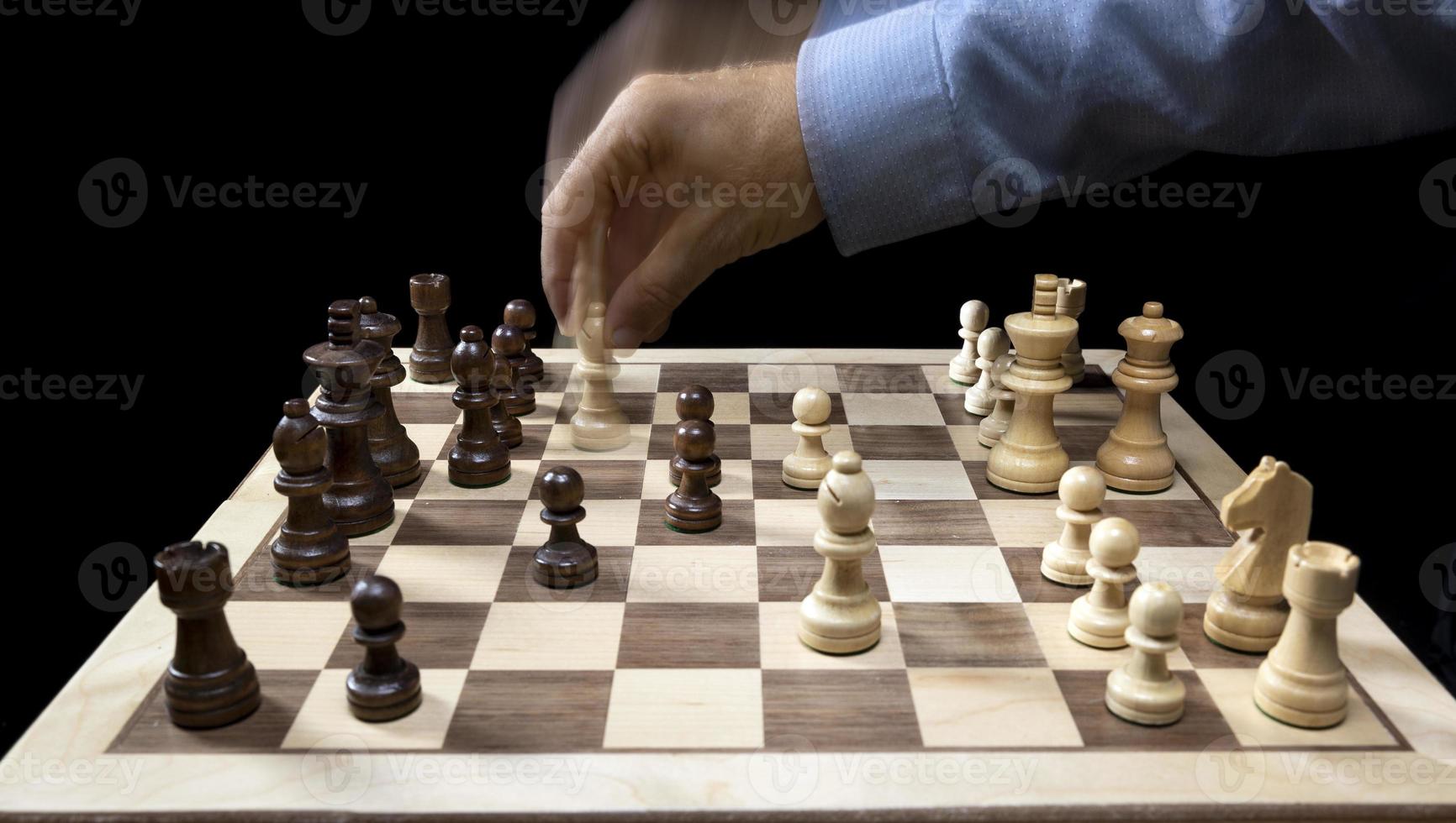 A chess board asnd pieces against black background photo