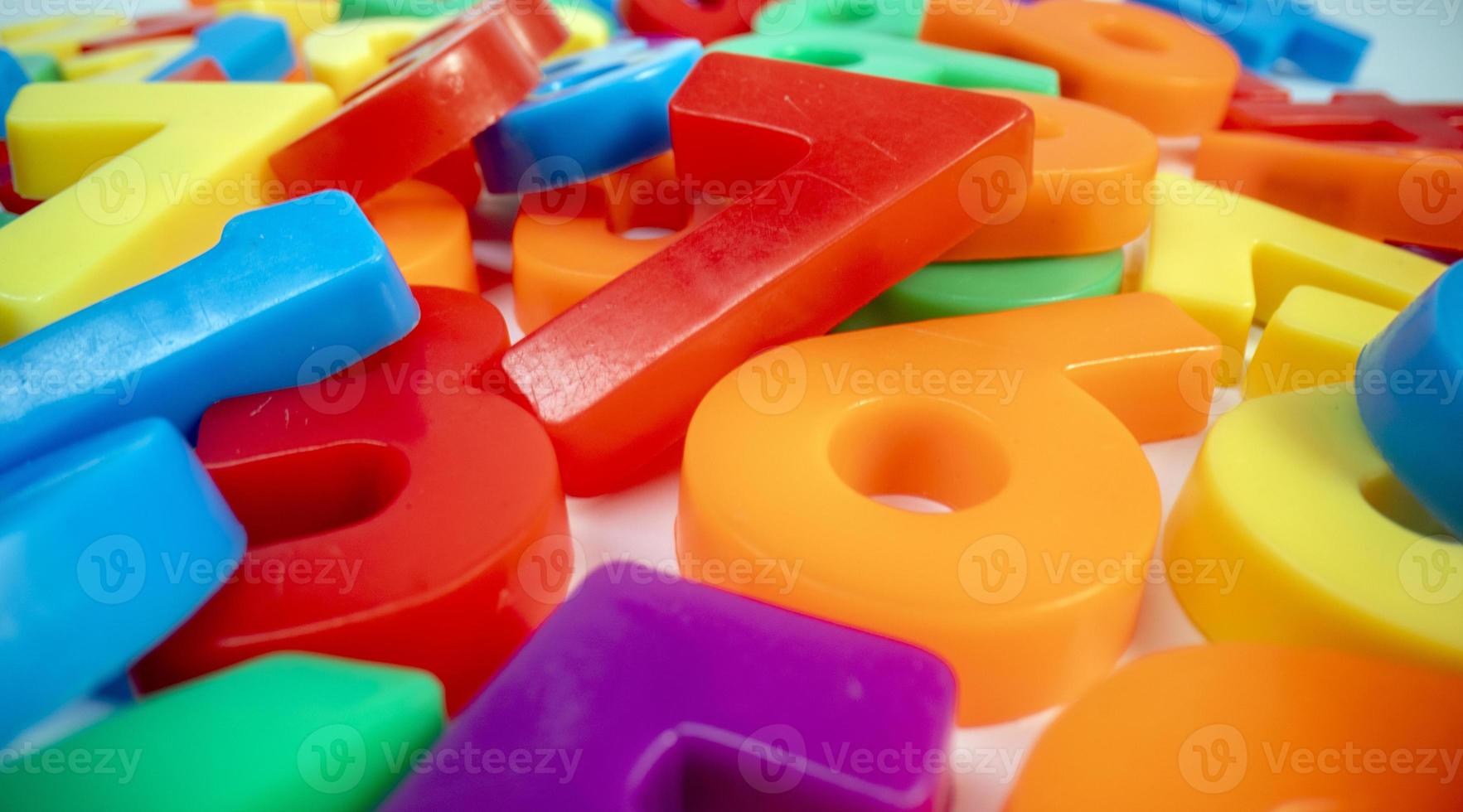 Macro shot of multi coloured magnetic numbers on plain white background photo