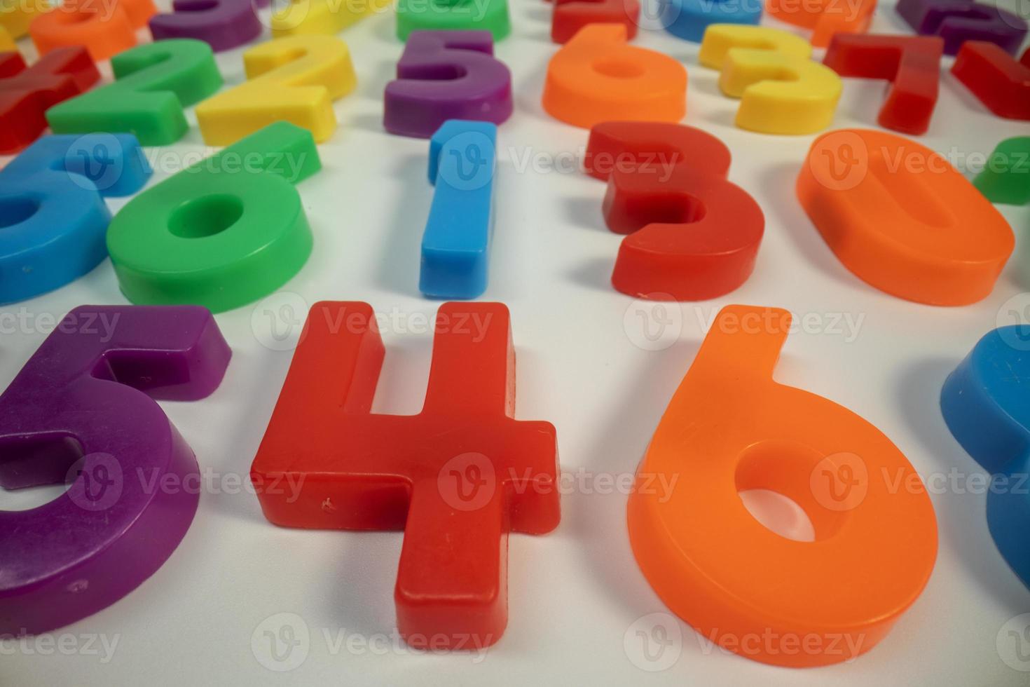Macro shot of multi coloured magnetic numbers on plain white background photo