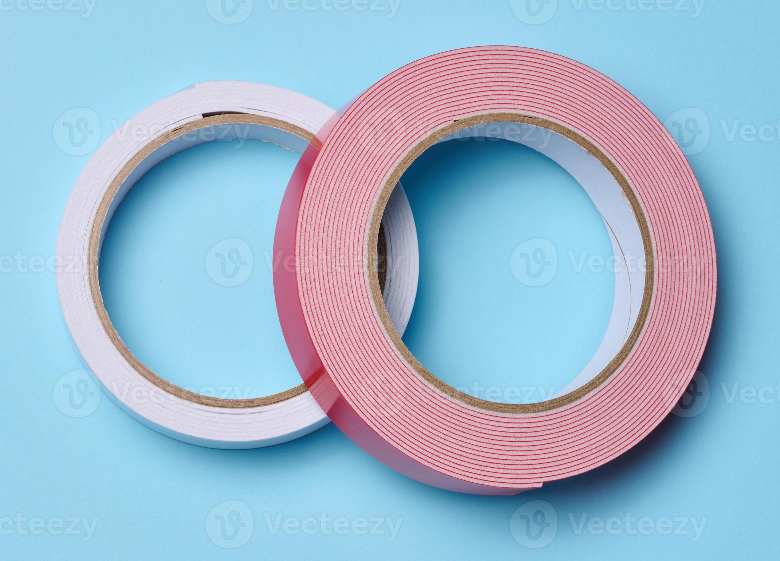 Two rolls of doublesided sticky tape on a blue background, top view