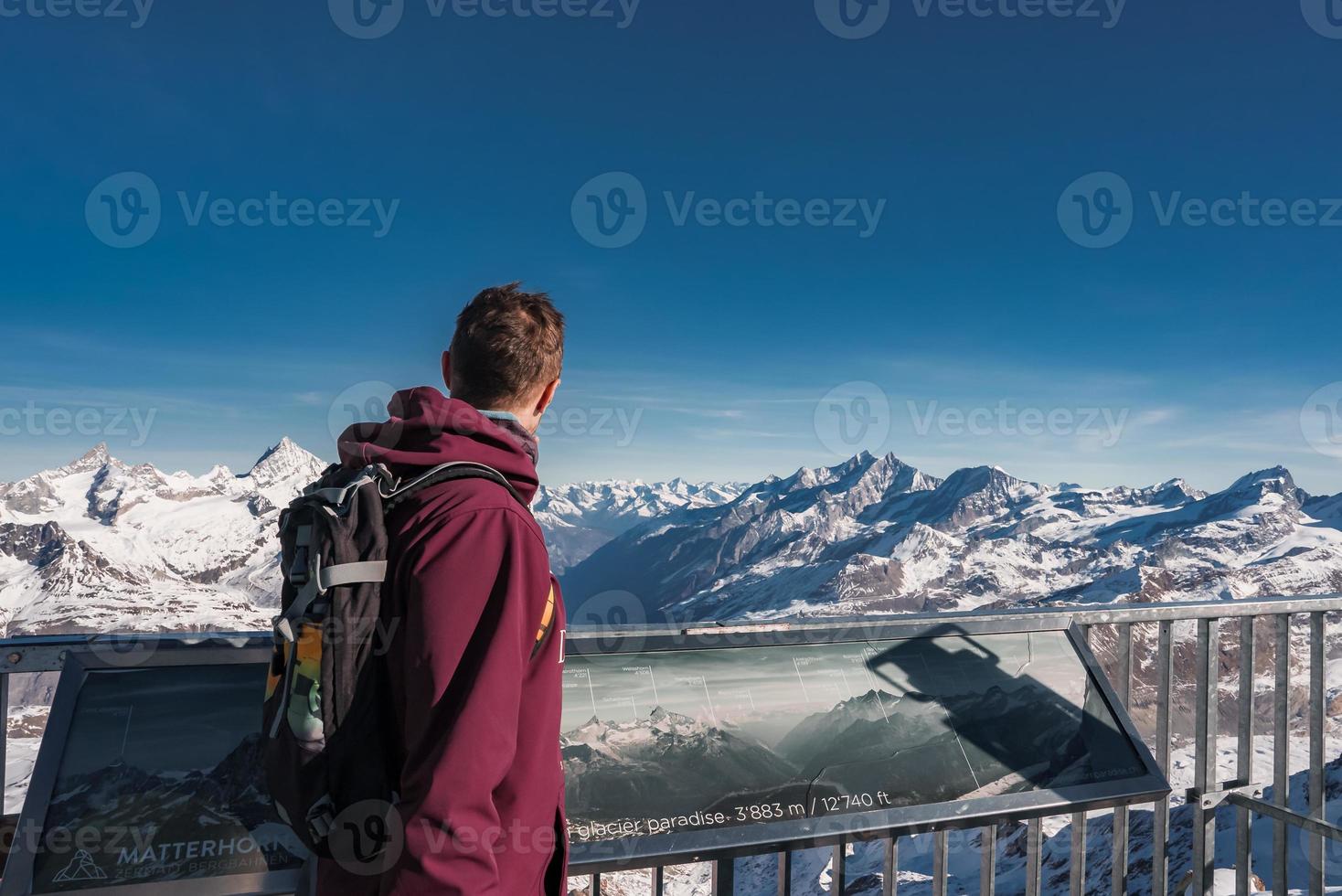 Young man at the peak of the Matterhorn Glacier Paradise. Exploring Swiss Alps from the top of the Glacier. photo