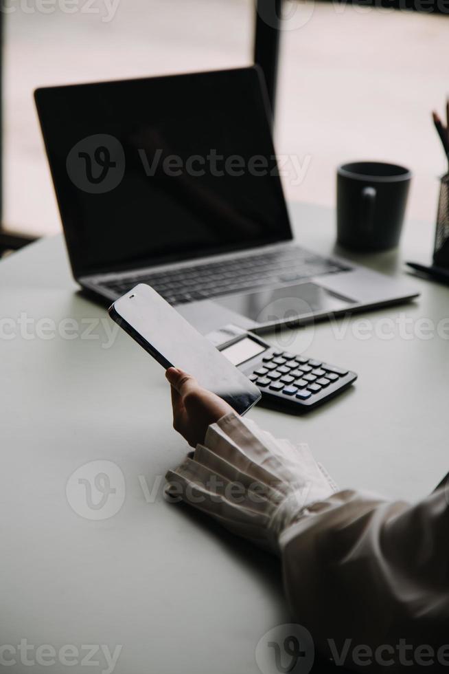 Teamwork of asian business people discussing and calculating with calculator on evaluation data in conference room. with the growth and pointing to the chart graph financial account. photo