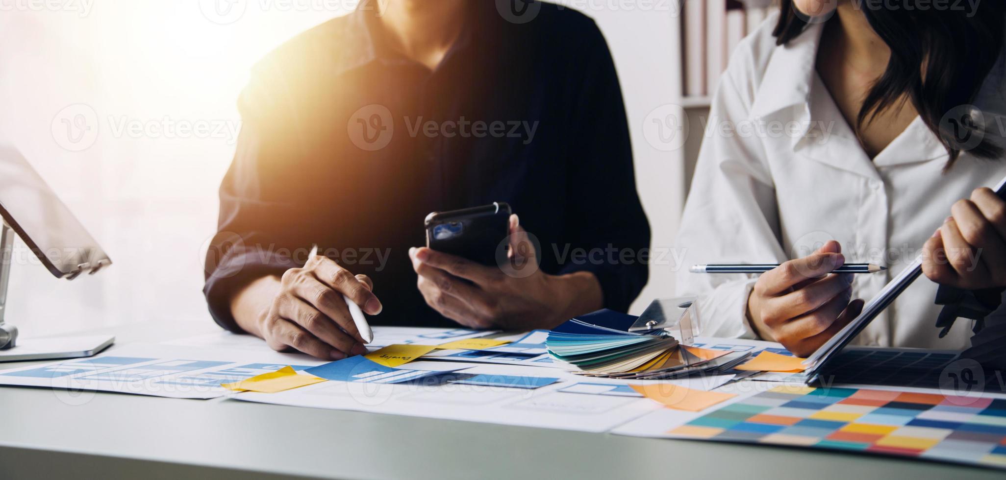 Close up ux developer and ui designer use augmented reality brainstorming about mobile app interface wireframe design on desk at modern office.Creative digital development agency photo