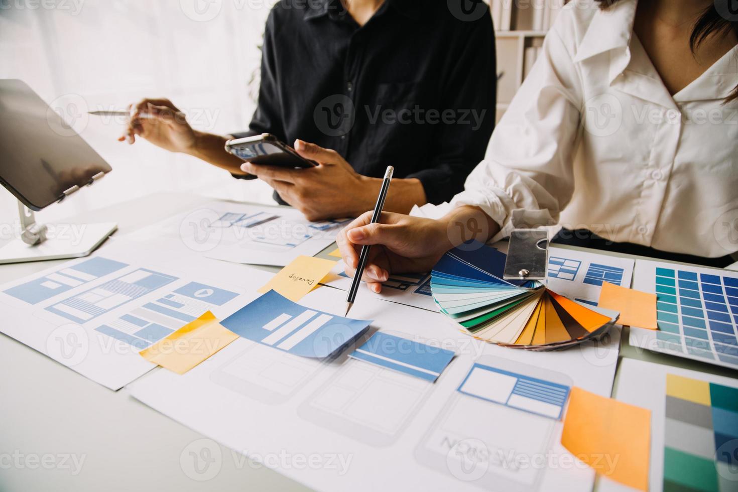 Close up ux developer and ui designer use augmented reality brainstorming about mobile app interface wireframe design on desk at modern office.Creative digital development agency photo
