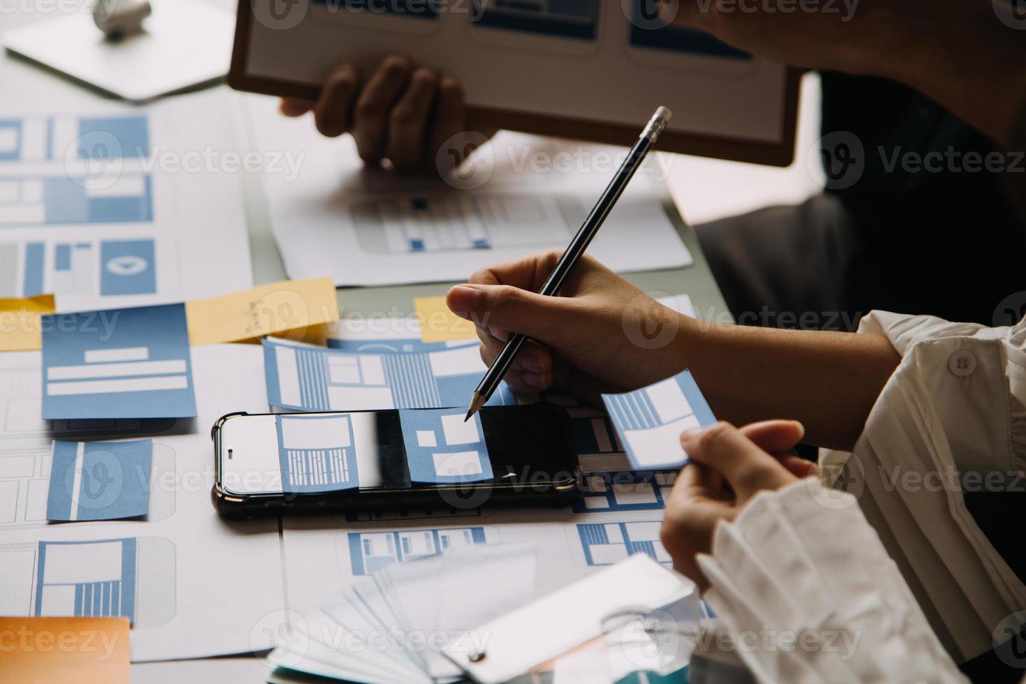 Close up ux developer and ui designer use augmented reality brainstorming about mobile app interface wireframe design on desk at modern office.Creative digital development agency photo